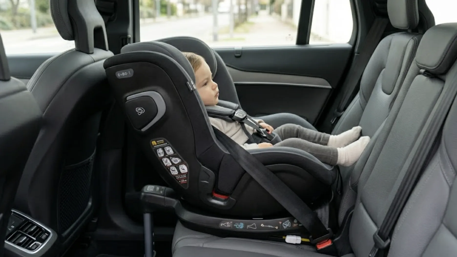 Enfant installé dos à la route dans un siège auto