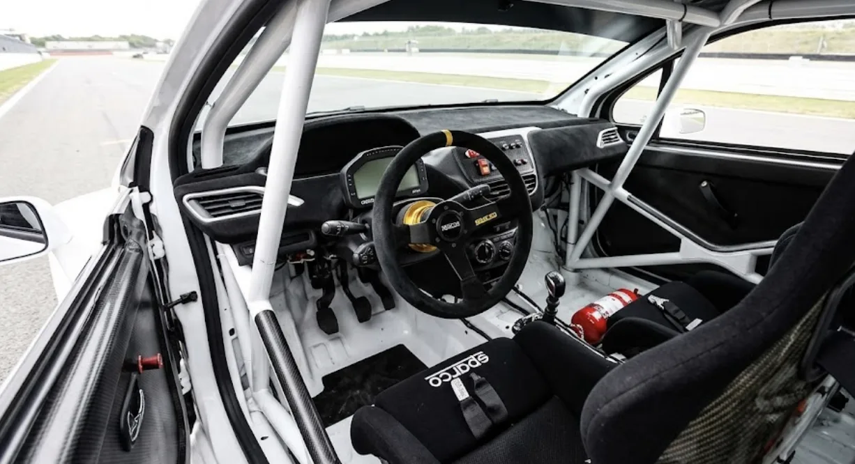 Peugeot 208 Racing Cup en action sur circuit, arceau FIA visible