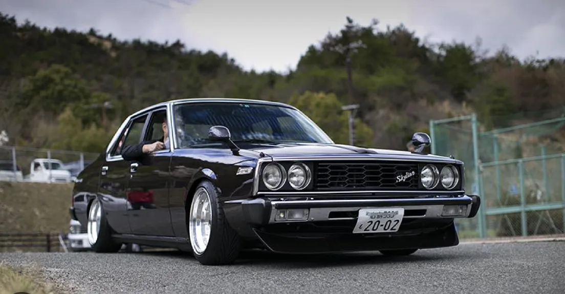 Nissan Skyline GT-R R34 blanche chargée dans un conteneur maritime sur un port japonais au crépuscule